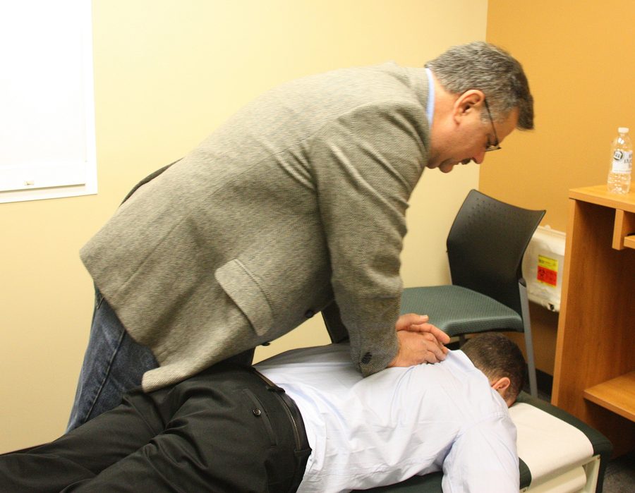 A chiropractor performing a spinal adjustment on a patient